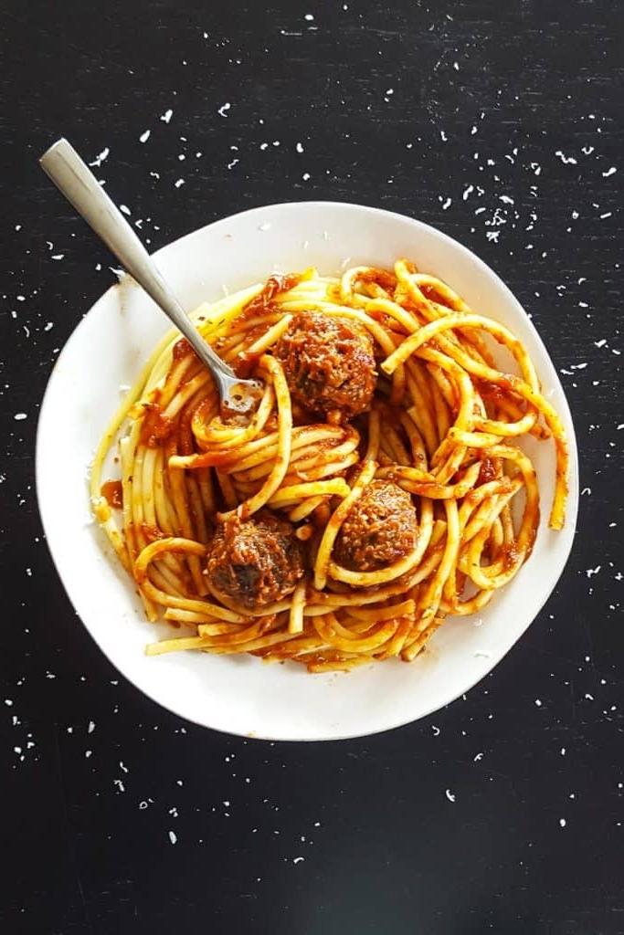 Spaghetti and meatballs in white bowl