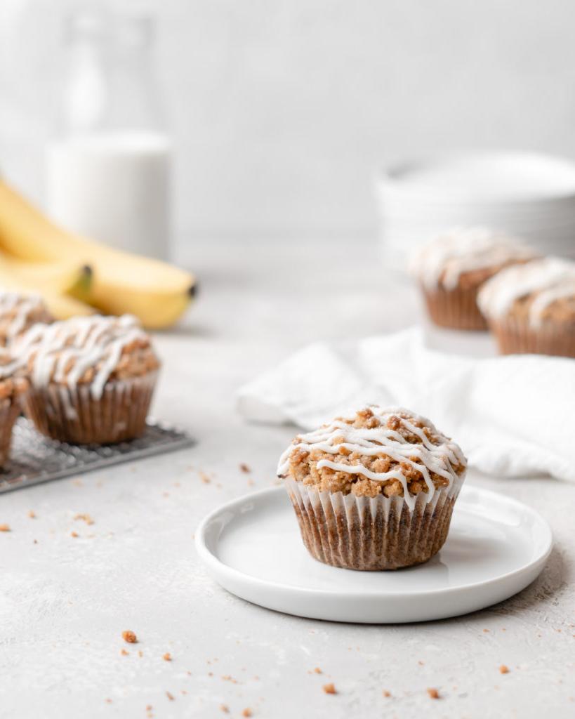 These moist banana muffins are topped with a buttery streusel topping and a simple creamy glaze!