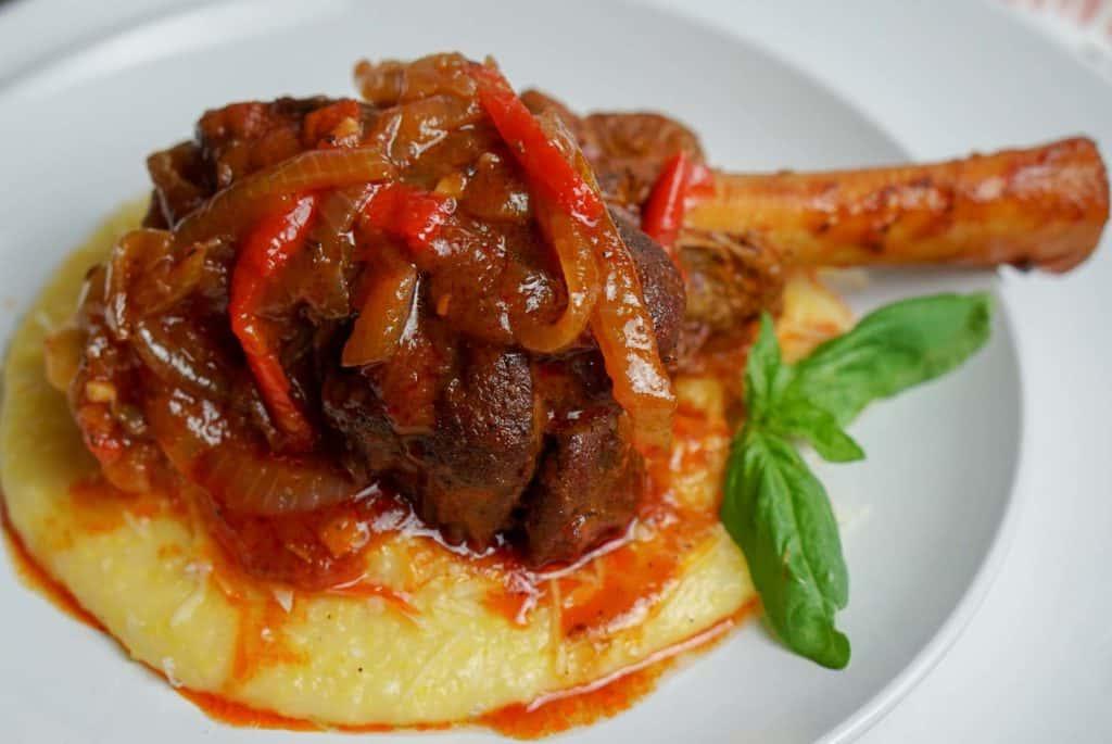 lamb shanks with polenta on white plate