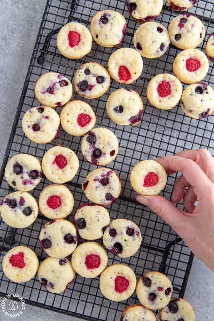hand grabbing mini pancake muffin off cooling rack