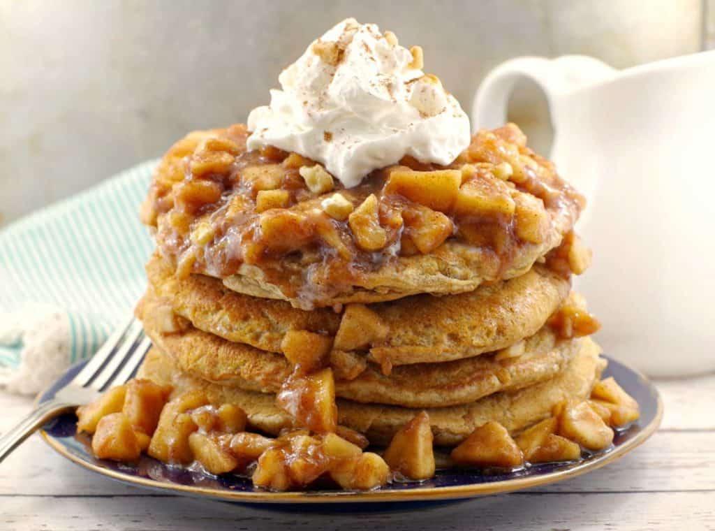 stack of pancakes topped with whipped cream