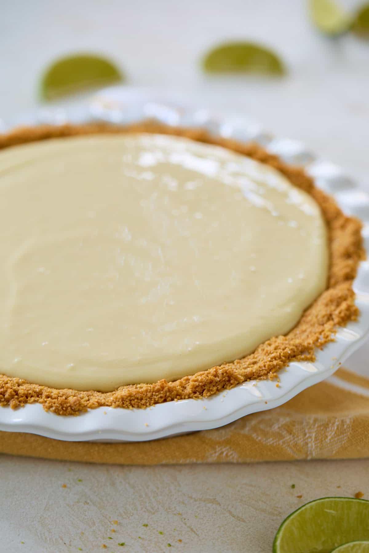 Unbaked Key Lime Pie filling poured into the graham cracker crust, ready to be baked.