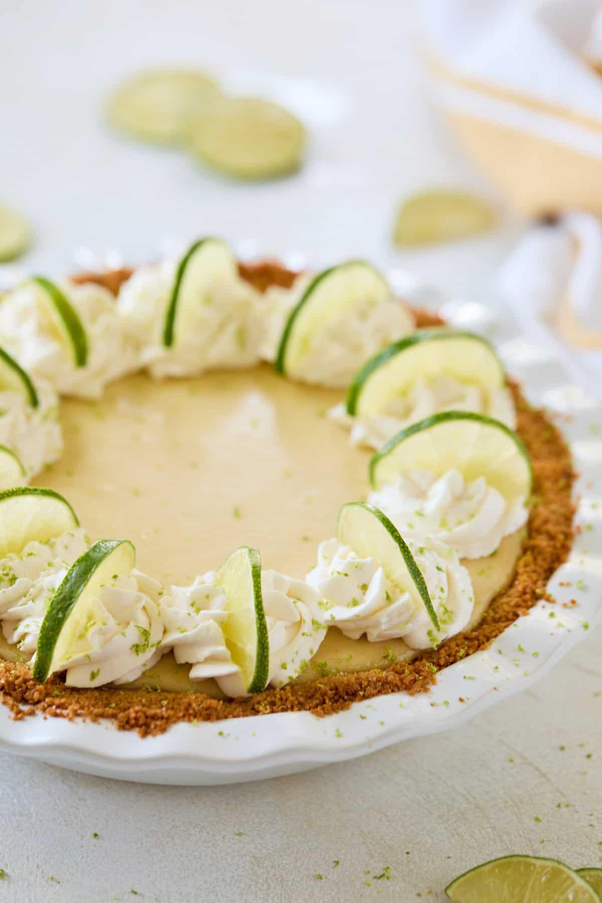 A decorated pie with whipped cream and lime slices, ready to be served.
