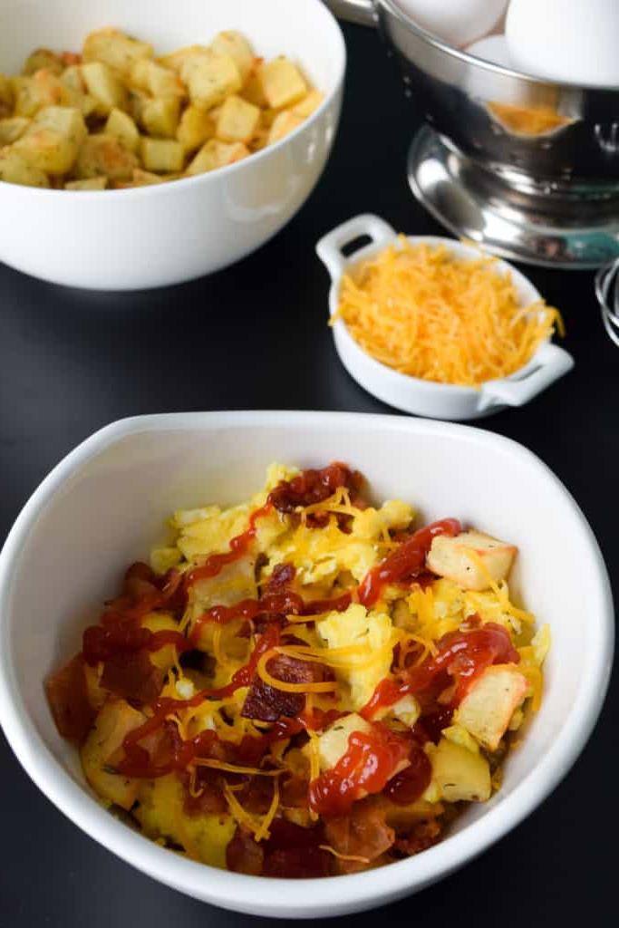 close up view of loaded breakfast bowls with ketchup on top