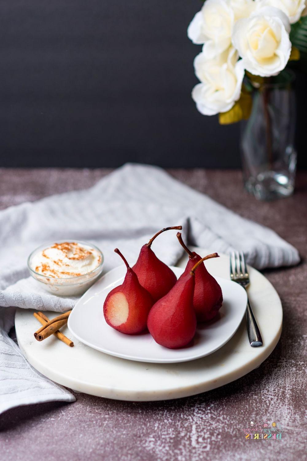 Poached pears in red wine of a white serving plate