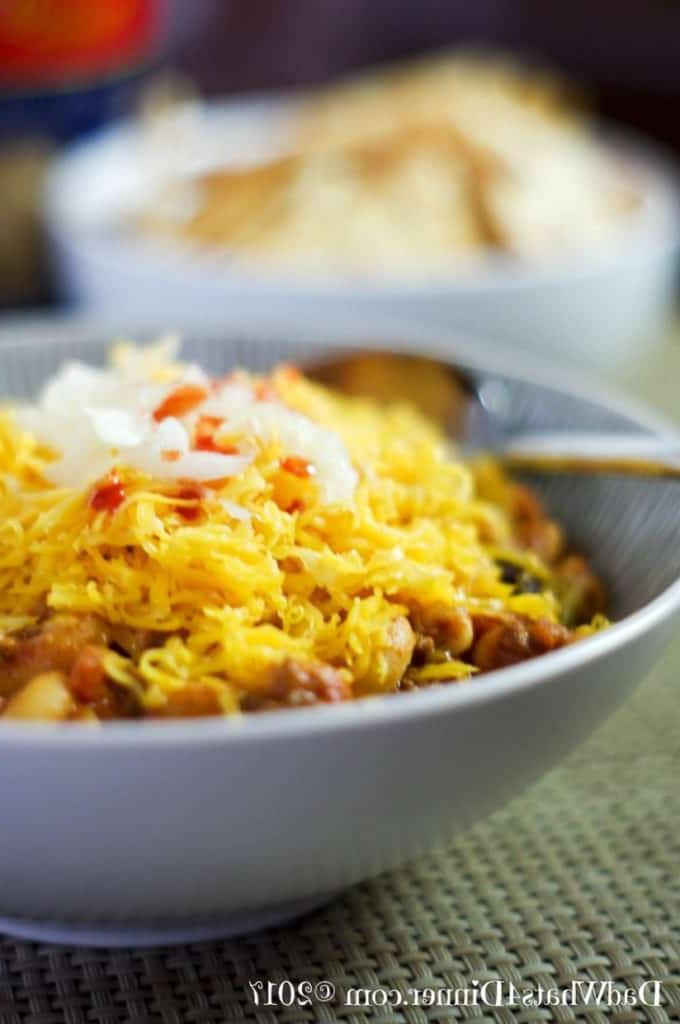 white bowl of chili Mac topped with cheese
