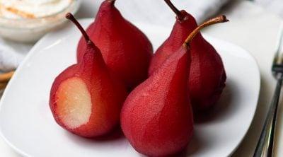 Close up image of wine poached pears on a white serving plate