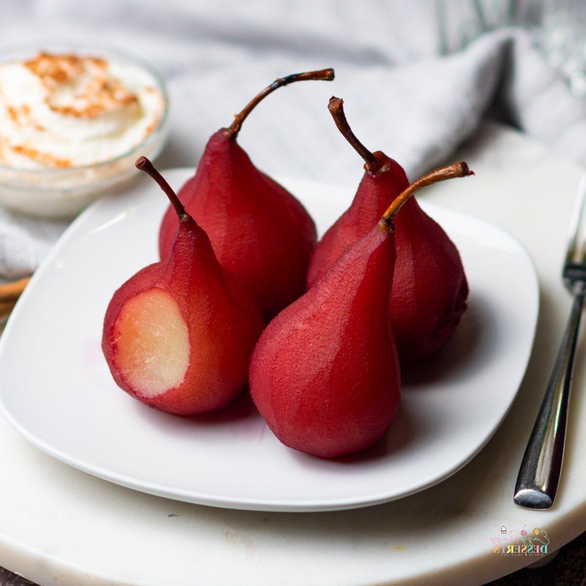 Close up image of wine poached pears on a white serving plate