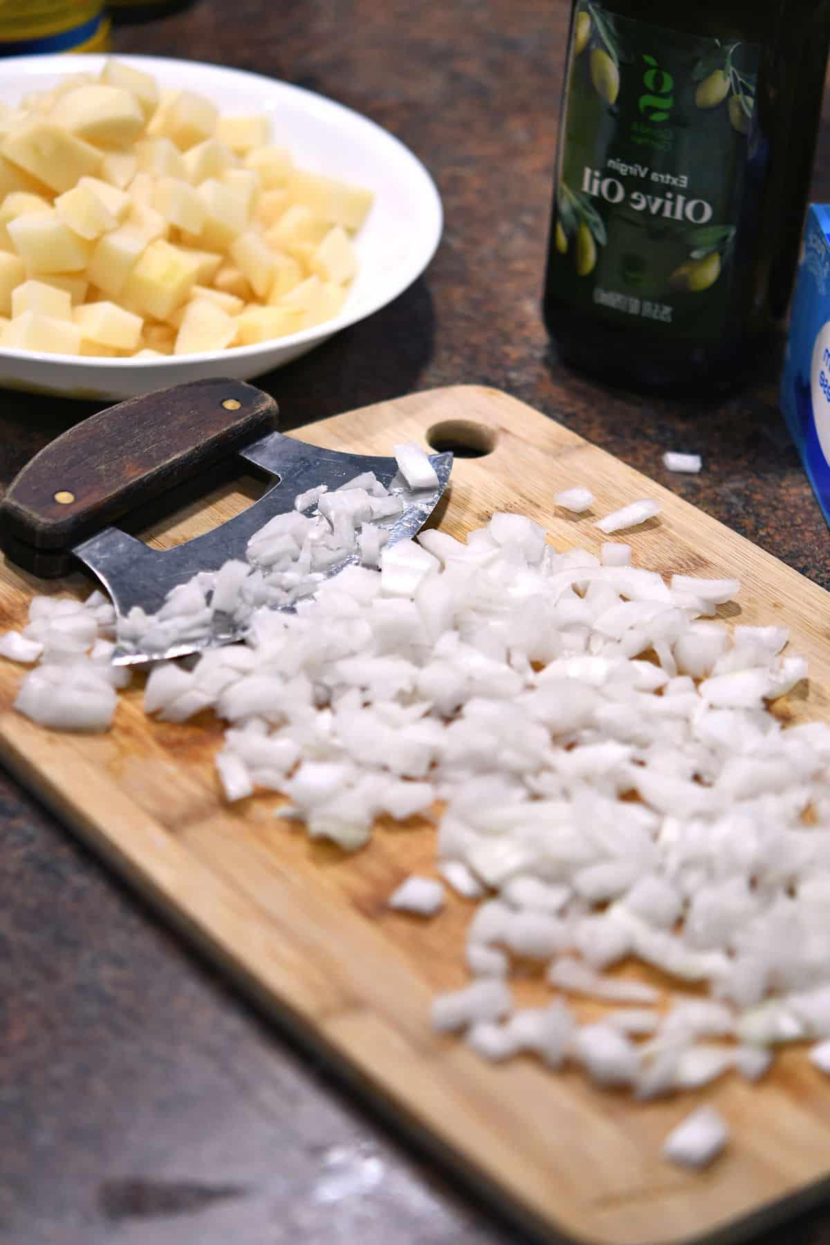 chopped onions and potatoes on a cutting board
